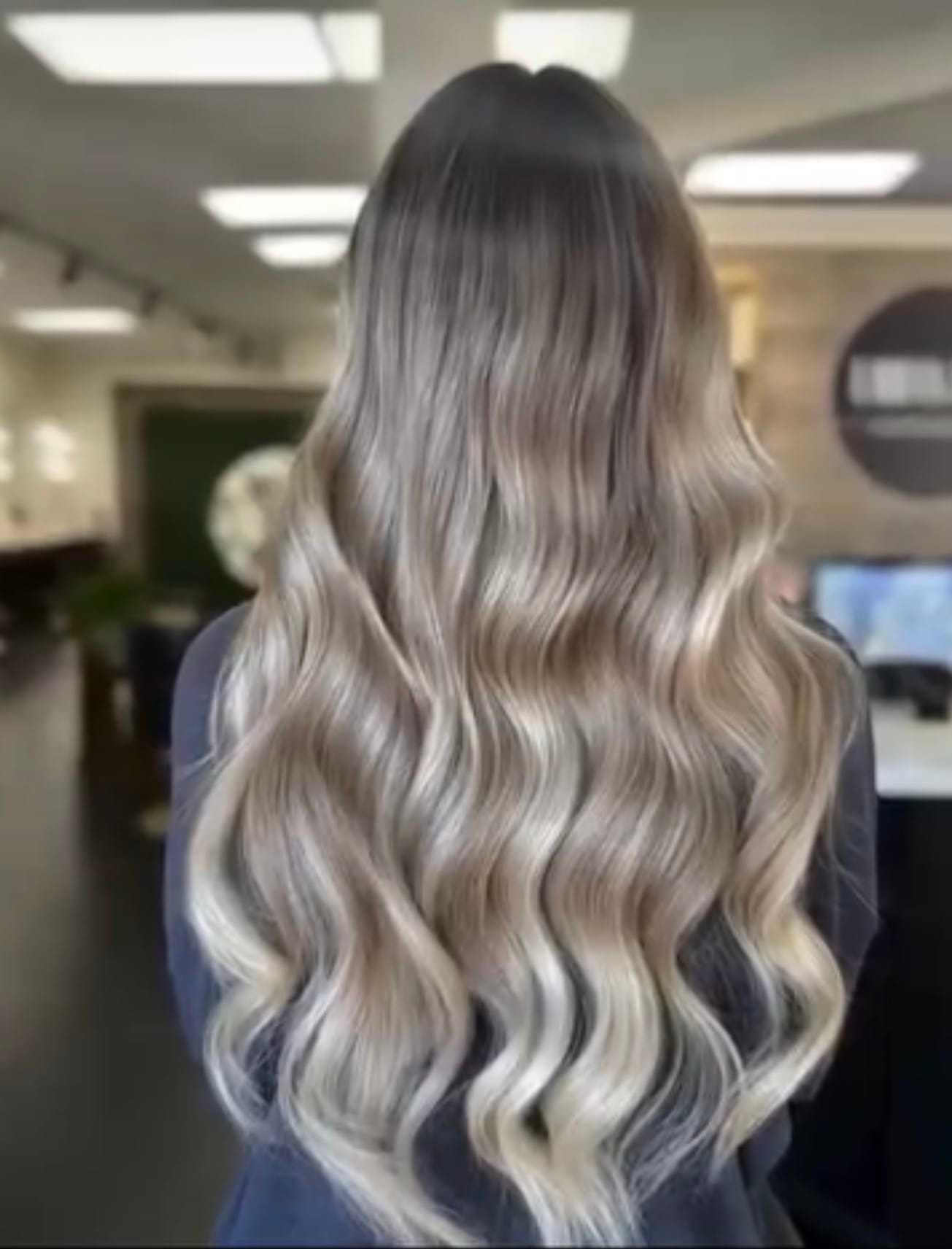 Long wavy blonde hair cascading in a salon setting.